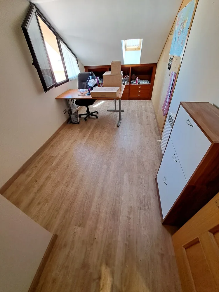 Despacho con suelo laminado marrón oscuro instalado